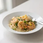 Shrimp scampi with garlic lemon pasta, shrimp, parsley, and Parmesan on a plate
