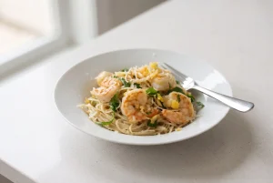 Shrimp scampi with garlic lemon pasta, shrimp, parsley, and Parmesan on a plate