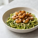Spicy shrimp pesto noodles with zucchini noodles and seasoned shrimp in a bowl